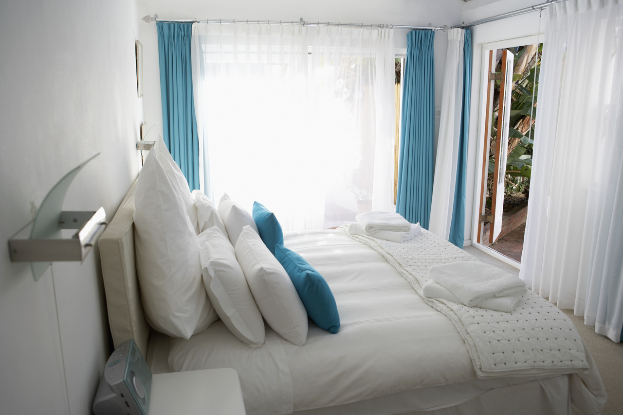 Шторы и тюль в спальне с балконом - фото